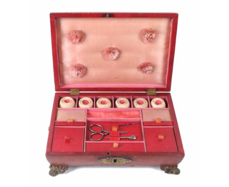 A Regency grained red leather sarcophagus form sewing box, the convex sides below a reeded lid panel rising to a gilt tablet,
