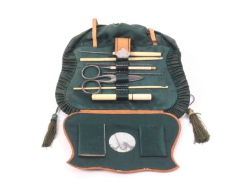 A mid-19th Century French sewing companion of bag form in diced leather, green silk and cut steel, interior with mirror (a/f)