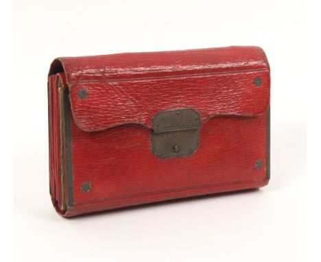 A Georgian red leather and silver mounted sewing companion of folding purse form, the interior partly in green silk with mirr