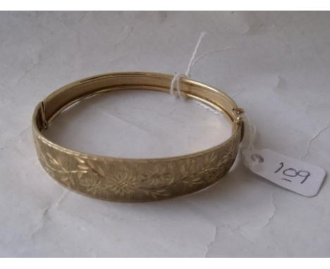 A good 9ct hinged bangle with frosted decoration  chased with flowers 10g      