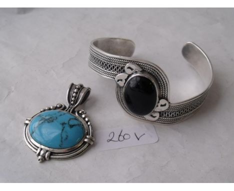 A foreign silver oval pendant also a silver bangle   