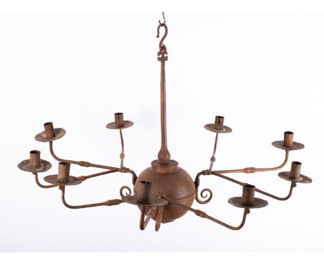 A wrought iron nine light chandelier in early 18th century taste; the cylindrical sockets and drip pans arranged in three gro