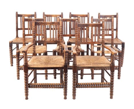 A set of nine oak and rush seated dining chairs, in Regency country taste, 20th century; including a pair of elbow chairs wit