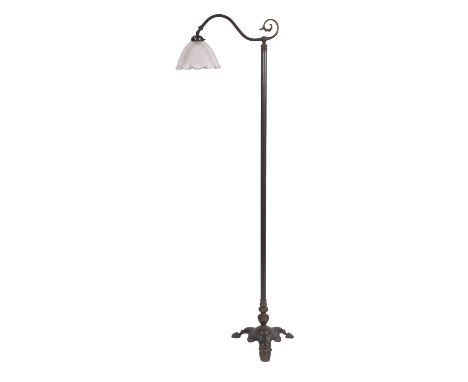 An Edwardian brass standard lamp, with projecting single branch light with glass shade on column and shaped triangular base w