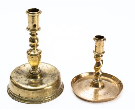 A brass candlestick, English or Dutch, early 18thcentury; the cylindrical socket with aperture, on a knopped stem to a broad 