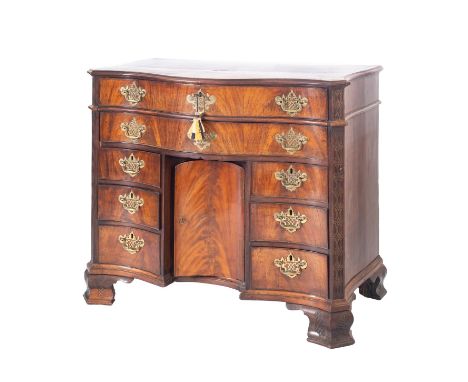 A 19th Century mahogany kneehole chest of serpentine outline in the Chippendale manner, the top with a moulded edge and proje