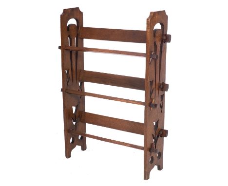 An oak three tier open book trough in the Arts and Crafts manner, with pierced fret pegged end supports, 55cm width, 84cm hei
