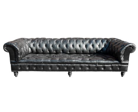 A black faux leather button upholstered Chesterfield sofa, in Regency taste, early 20th century; with outscrolled arms, on tu