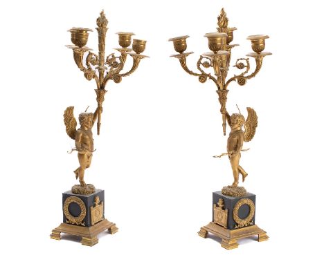 A pair of Empire gilt and patinated bronze four light figural candelabra, early 19th century; each with engine milled urn soc