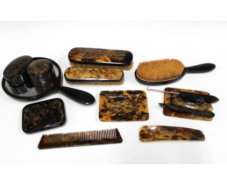 Vintage tortoiseshell dressing table vanity set, decorated with dragons, to include brushes, a comb, pots, mirror etc and a s