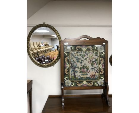 An oak framed tapestry fire screen together with an oval bevelled edge gilt framed mirror