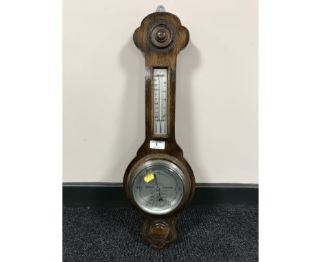 An oak cased barometer with silvered dial. 