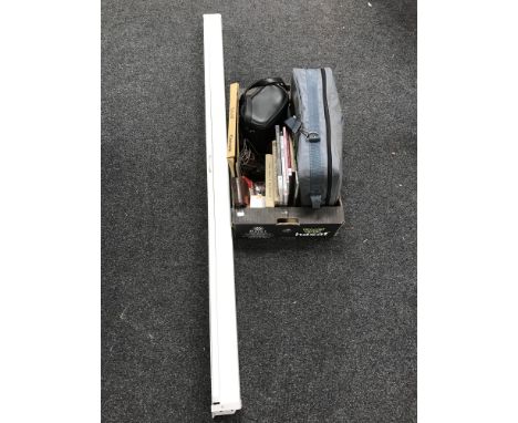 A box of books relating to photography, cameras and a pull down projector screen 