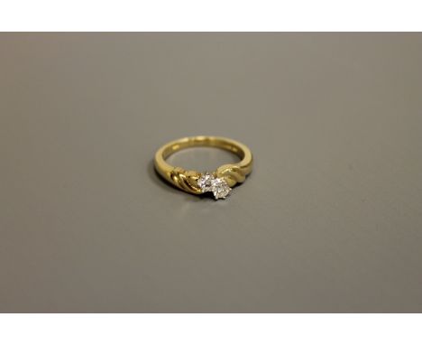 An 18ct gold two-stone diamond ring, approximately 0.2ct, size M/N.