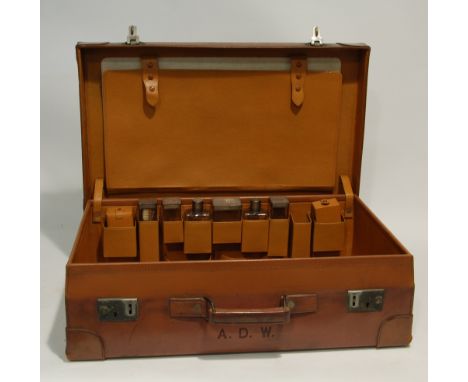 GOOD QUALITY 1940s LEATHER FITTED SUITCASE containing six toilet jars and bottles with engine turned silver tops, London 1942
