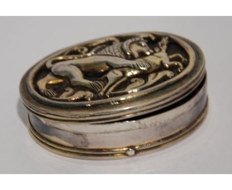 ANTIQUE MIDDLE EASTERN PLATED METAL OVAL SNUFF BOX the hinged lid applied with a cast open work image of a lion attacking an 