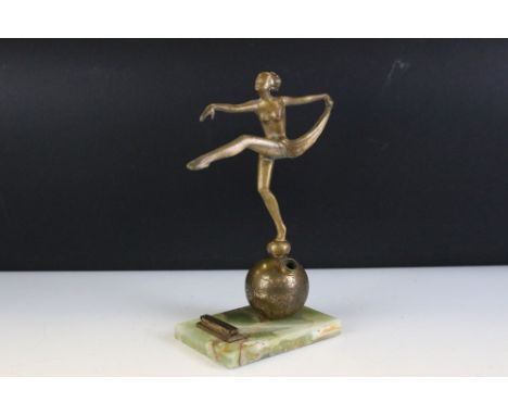 Art Deco gilt metal table lighter in the form of a semi-nude lady dancer raised upon a globe, green onyx base, approx 20.5cm 