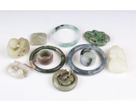 A collection of eleven pieces of carved Jade to include bangles and ornamental figures. 