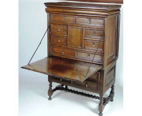 A rare William & Mary, and later, Oak Secretaire on Stand, the upper portion with secret frieze drawers and large decorated c