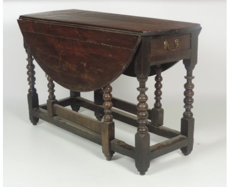 A good early 18th Century oak gate-leg falling leaf Dining Table, with short frieze drawer on eight bobbin turned support leg