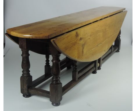 A very large and unusual falling leaf Hunt or Wakes type Table, the light coloured oak top with falling leaves, over a dark o