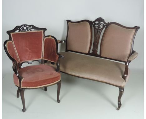 An Edwardian two seat walnut Settee, covered in light pink draylon; and a pair of Edwardian upholstered Elbow Chairs, with sh