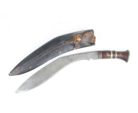 A 20th century kukri, having a curved 32cm blade and brass mounted handle, in leather sheath, with karda and chakmak, 45cm.