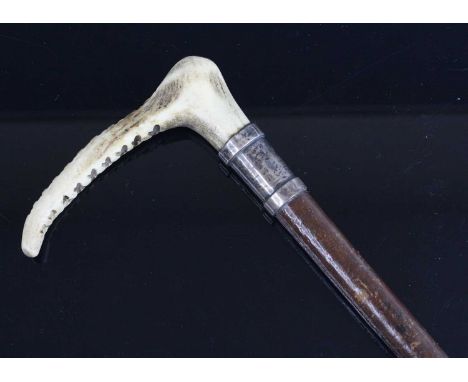 An Edwardian riding crop, having a leather covered shaft with silver collars, the stag antler handle with Swaine &amp; Adeney
