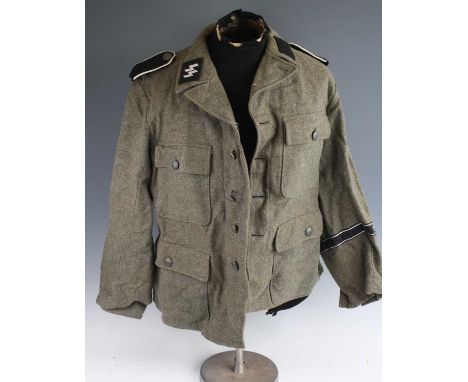 A collection of reenactors military uniforms and equipment to include a German tunic, leather boots, steel helmet, camouflage