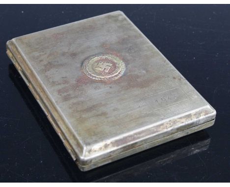 A German Third Reich nickel plated pocket cigarette case, of rectangular form the hinged cover with swastika within wreath an