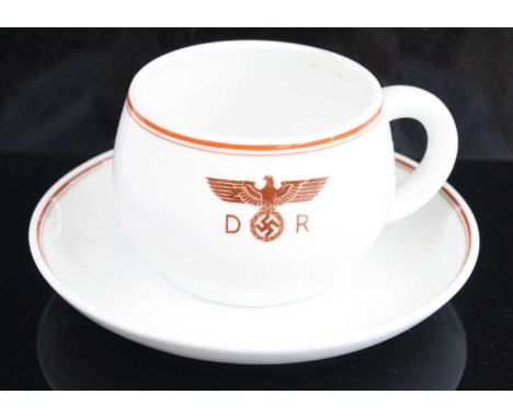 A Nymphenburg porcelain tea cup and saucer, each with red and gilt banding the cup with German eagle flanked by D R, together