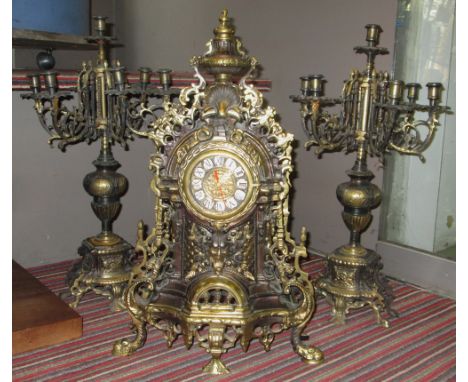 CLOCK GARNITURE, Louis XVI style brass with battery operated movement and a pair of matching seven light candelabra, clock 55