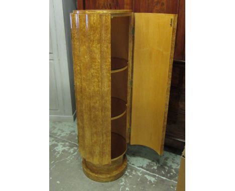 TALL NARROW CABINET, Art Deco style of cylindrical form with a cupboard door enclosing peach coloured glass topped shelves, 4