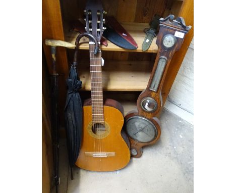 An acoustic guitar, a barometer and 2 umbrellas 