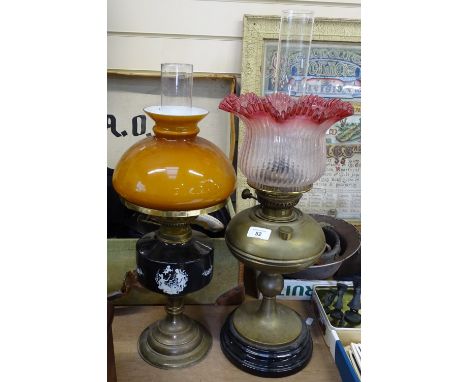 A brass oil lamp with a cranberry glass shade and chimney, height 61cm, and another oil lamp 
