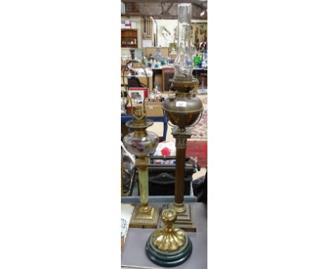 A brass oil lamp with fluted column with chimney, 91cm, dolphin lamp, and a brass lamp base and another (4) 