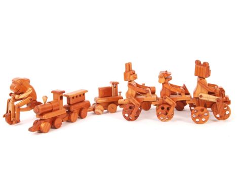 A collection of Chester Wedgewood's handmade wooden carved push along animals and train to include; a linked bear, frog and r