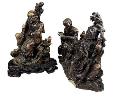 THREE CHINESE HARDSTONE FIGURES, depicting figures at worship. One mounted on a wooden base with carved shells, all numbered 