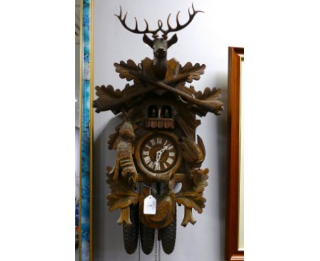 Black forest style cuckoo clock decorated with Stag, guns, Hare etc with three weights