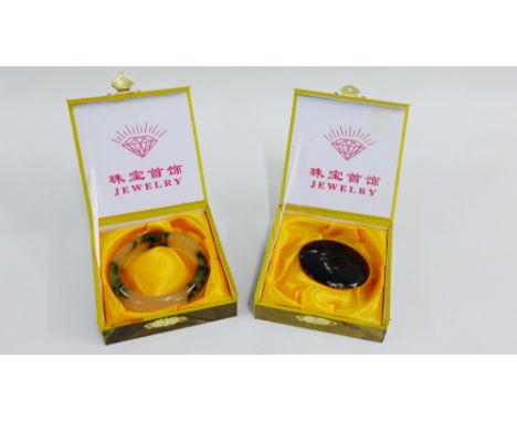 Jade bangle together with a hardstone bi disc pendant, both boxed (2) 