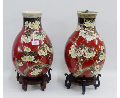 Pair of Japanese earthenware baluster vases, one with a lamp fitting to top, both with hardwood wooden stands, height overall