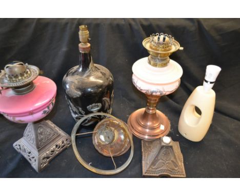 Lighting - a late 19th century paraffin oil lamp, opaque pink glass reservoir; another, similar, later; etc (4)  **All lots i