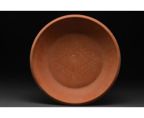 Ca. 300-400 AD.A finely made terra sigillata bowl, with a squat form that rests atop a flat base. The vessel includes broad w