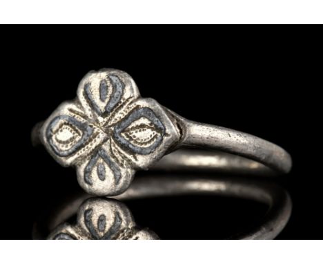 European, Ca.1200-1300 AD.A silver ring comprising a thin circular band and an applied four-petal, flower-shaped bezel with b