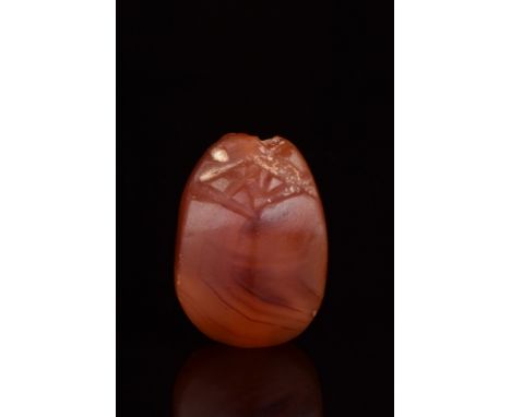 Ca. 664-332 BC.A finely modelled carnelian scarab with its oval body gently rounded, upper side detailing the clypeus, protho