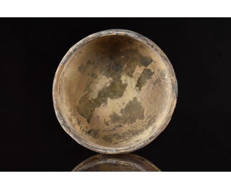 Ca. 200-300 AD.A yelllow glass bowl with a high-walled thickened rim and a slightly concave base. Some weathering and incrust