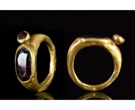 Ca. 200-300 AD.A gold finger ring of unusual design featuring a plain band and rounded bezel which is incorporating a large c