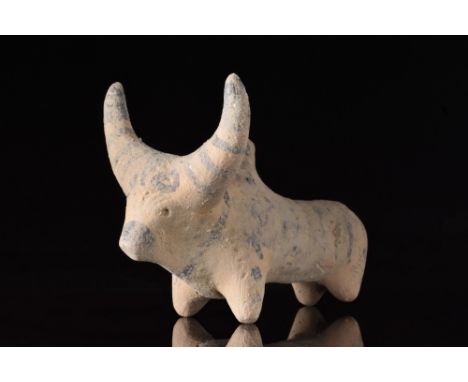 Ca. 3rd millennium BC.A cream-coloured ceramic figurine of a zebu bull with rondel eyes. Painted with stripes and dots on the