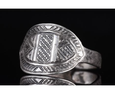 Ca. 1100-1300.A beautiful silver ring with a circular band embellished with linear decoration. The curved oval bezel is embel