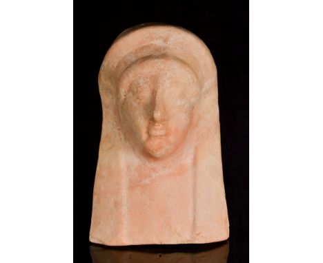 Ca. 600-500 BC.A large terracotta protome depicting a lovely goddess with well-modeled facial features wearing a long headdre